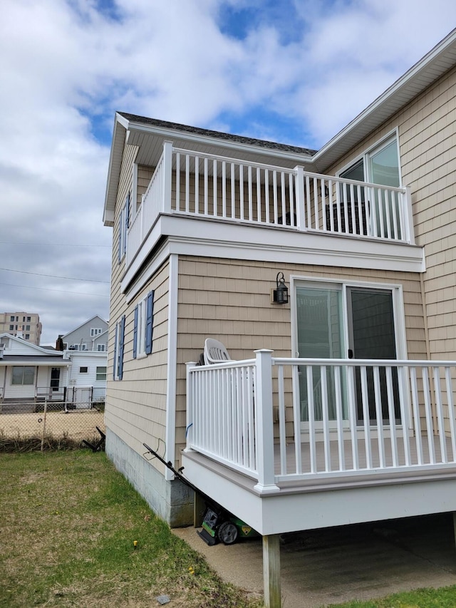 back of house featuring a balcony and a yard