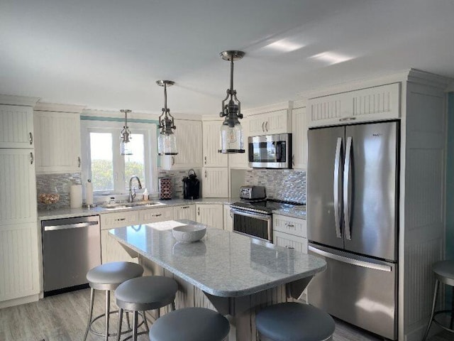 kitchen featuring backsplash, appliances with stainless steel finishes, sink, and light wood-type flooring