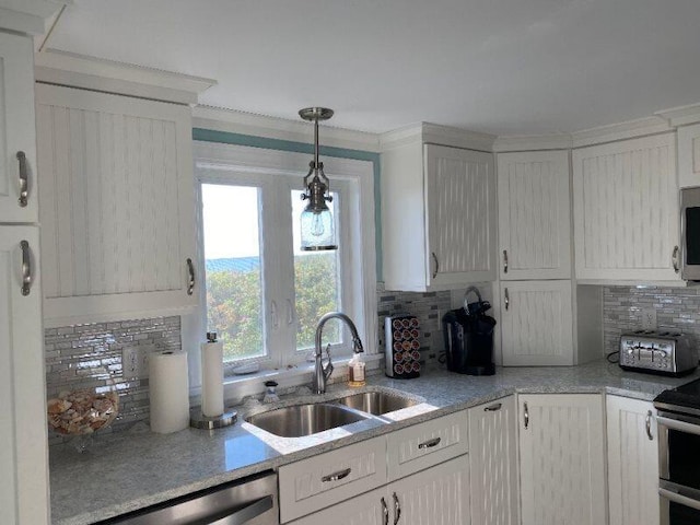 kitchen with backsplash, stainless steel appliances, sink, and hanging light fixtures