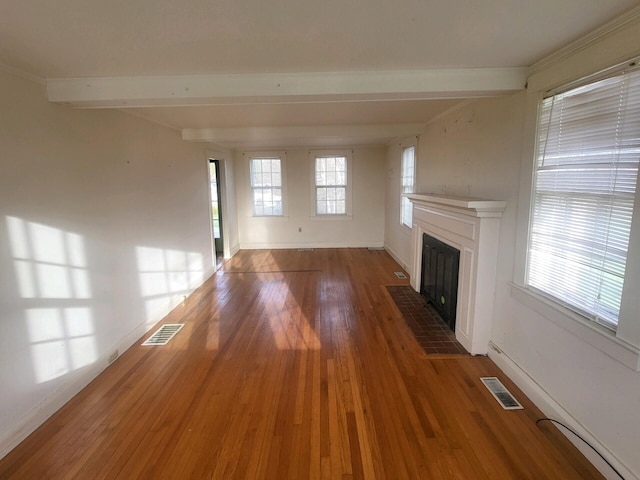 unfurnished living room featuring hardwood / wood-style floors and beam ceiling