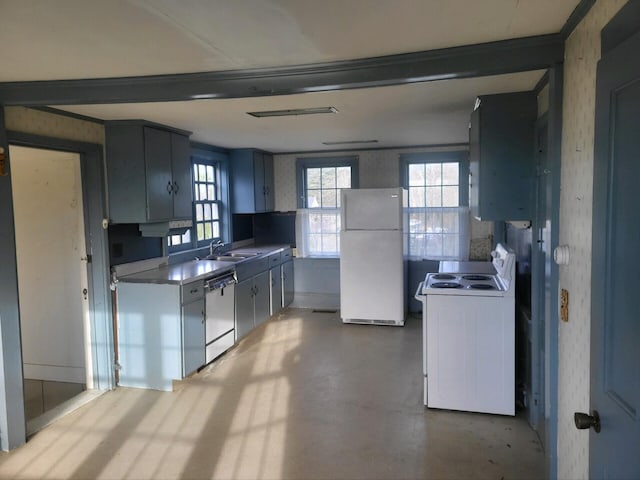 kitchen with beamed ceiling, white appliances, and sink