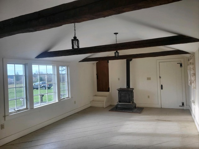 unfurnished living room featuring a wood stove, light hardwood / wood-style flooring, and lofted ceiling with beams