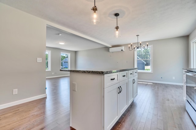 kitchen featuring hardwood / wood-style flooring, plenty of natural light, decorative light fixtures, and white cabinetry