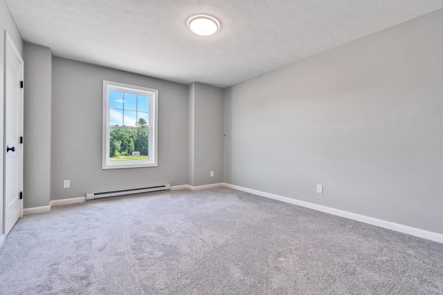 spare room featuring a baseboard heating unit, carpet, and a textured ceiling