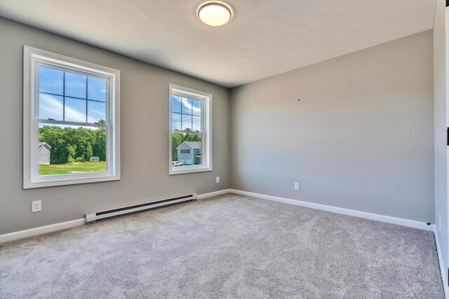 unfurnished room featuring carpet flooring and a baseboard heating unit