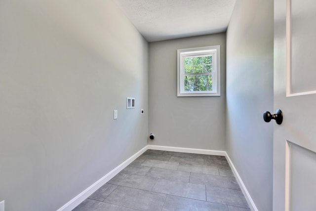 washroom featuring washer hookup, hookup for an electric dryer, tile floors, and a textured ceiling