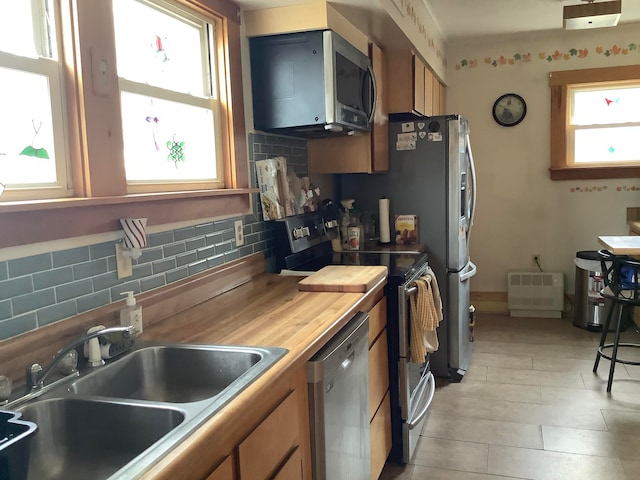 kitchen featuring appliances with stainless steel finishes, tasteful backsplash, and sink