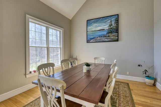 dining room with lofted ceiling, baseboards, and hardwood / wood-style flooring