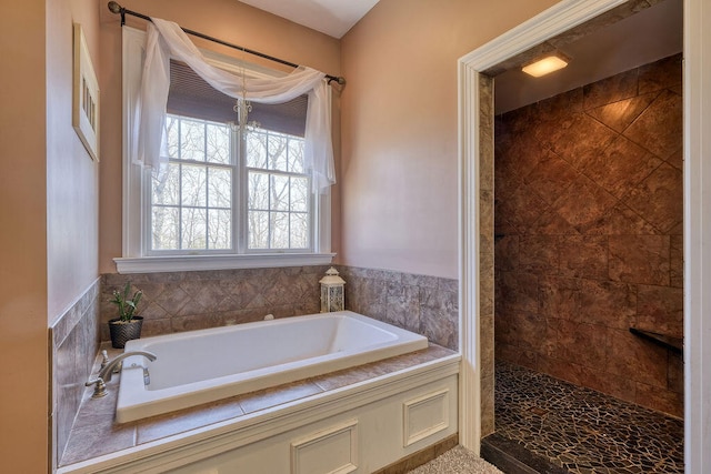 bathroom featuring a garden tub and a tile shower