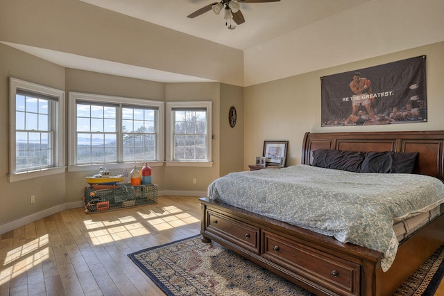 bedroom featuring light wood-style floors, multiple windows, and baseboards