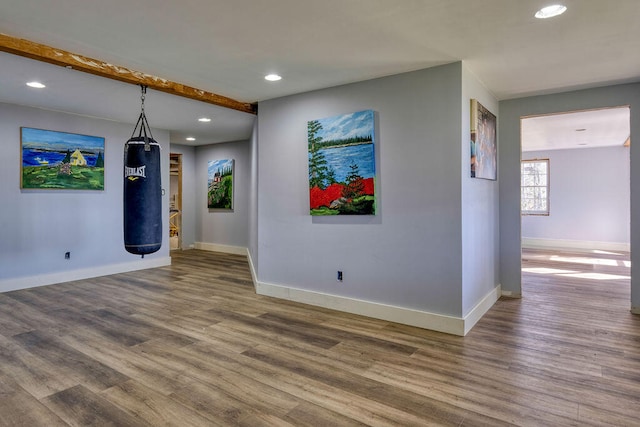 unfurnished room featuring recessed lighting, wood finished floors, and baseboards