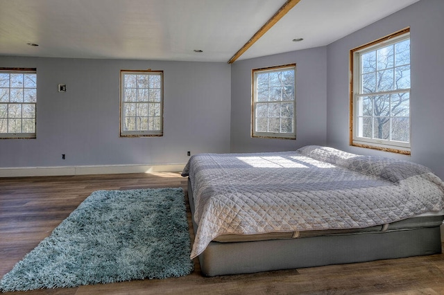 bedroom with multiple windows, baseboards, and dark wood-type flooring