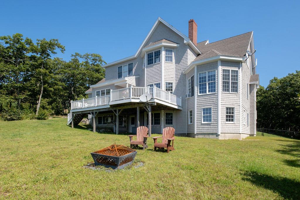 25 Browns Ave, Sedgwick, ME 04676 - rear view of property with an outdoor fire pit, a deck, a yard, a chimney, and a shingled roof