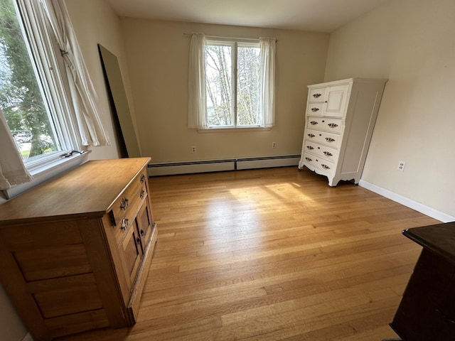 bedroom featuring light wood-type flooring and a baseboard radiator