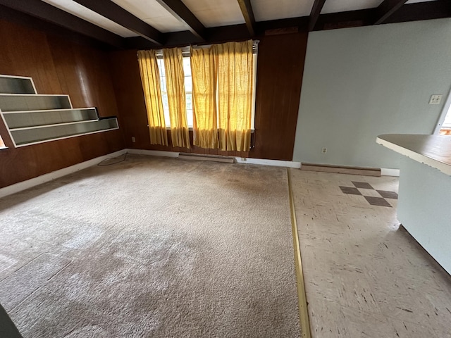 unfurnished living room featuring beam ceiling and wooden walls