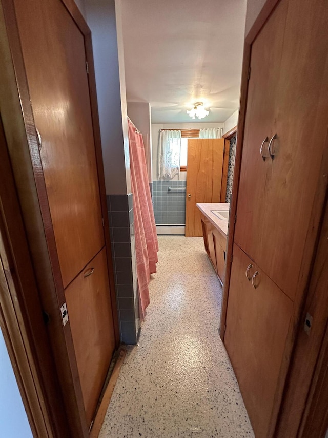 bathroom with vanity, baseboard heating, and curtained shower