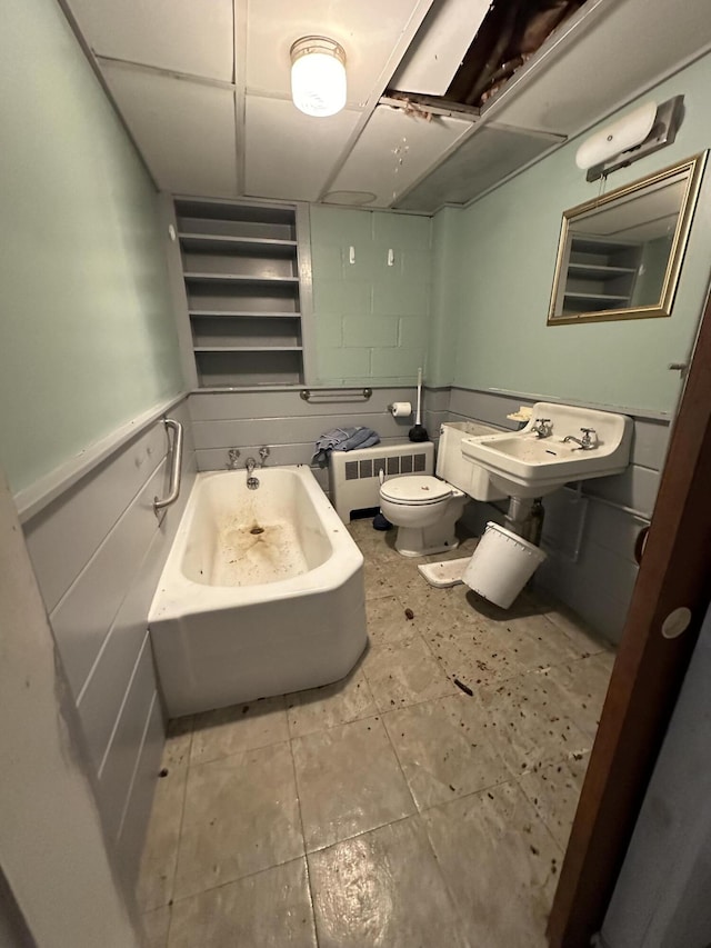 bathroom featuring toilet, radiator, sink, and a washtub