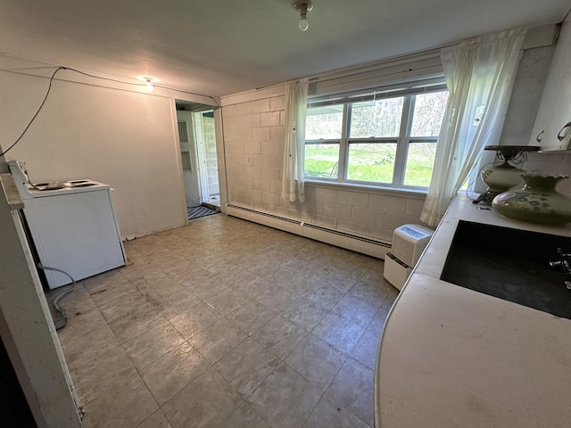 interior space with washer / clothes dryer and a baseboard heating unit