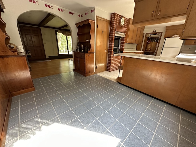 kitchen featuring white refrigerator and kitchen peninsula