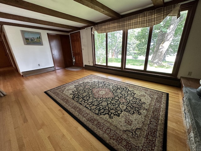 interior space with a baseboard heating unit, plenty of natural light, hardwood / wood-style floors, and beamed ceiling