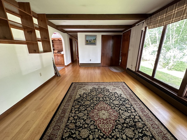 hall featuring light hardwood / wood-style floors, a baseboard radiator, and beamed ceiling