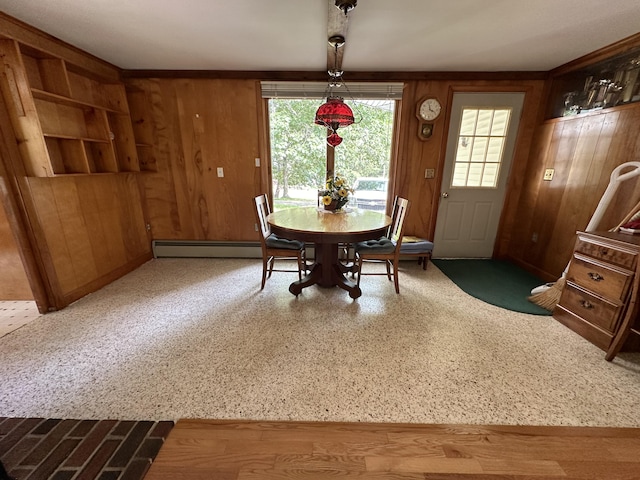 dining space with a baseboard heating unit and wooden walls