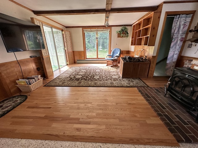 misc room featuring beam ceiling, wood-type flooring, wooden walls, and a baseboard radiator