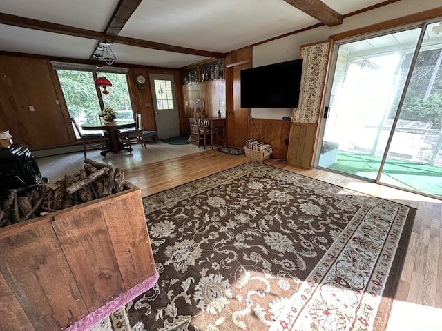 living room with beam ceiling, wood walls, a baseboard radiator, and hardwood / wood-style flooring