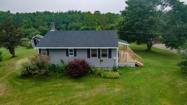 view of side of property with a wooden deck and a lawn