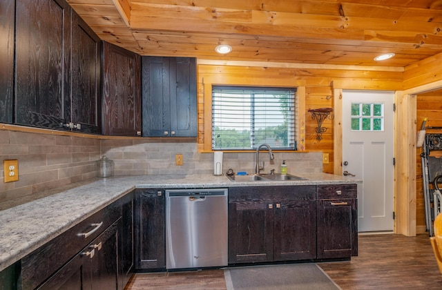 kitchen with sink, dark wood-type flooring, light stone counters, tasteful backsplash, and stainless steel dishwasher