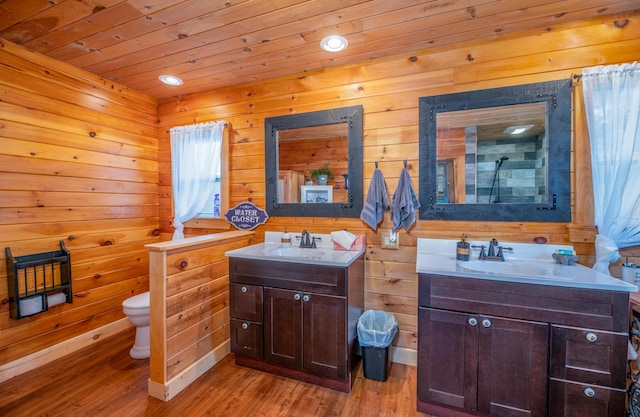 bathroom featuring toilet, wooden ceiling, vanity, wooden walls, and hardwood / wood-style floors