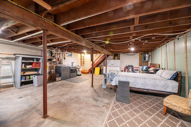 basement featuring washing machine and clothes dryer and electric panel