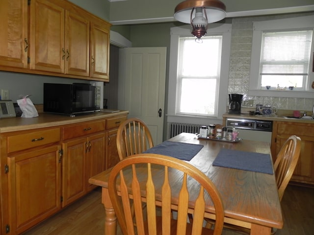 kitchen featuring dark wood-type flooring, radiator heating unit, and backsplash