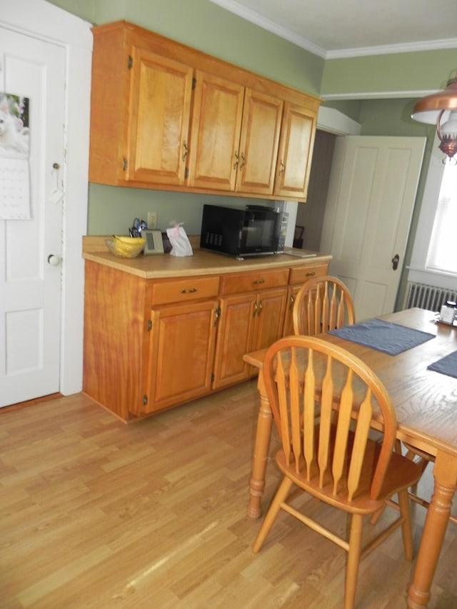 kitchen with ornamental molding and light hardwood / wood-style floors