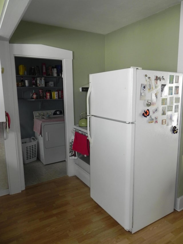 kitchen featuring hardwood / wood-style floors, white fridge, and washer / clothes dryer