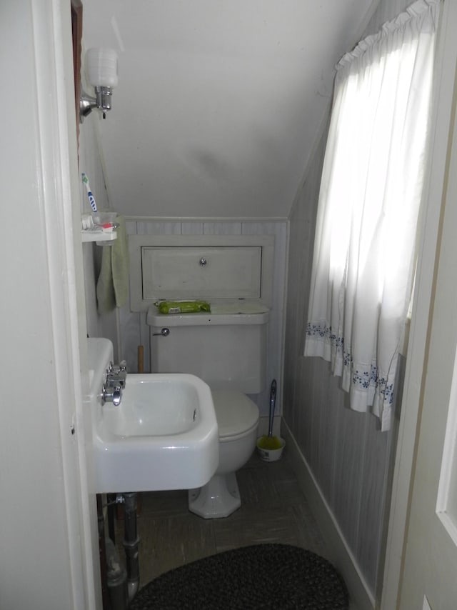 bathroom featuring sink, tile flooring, toilet, and lofted ceiling