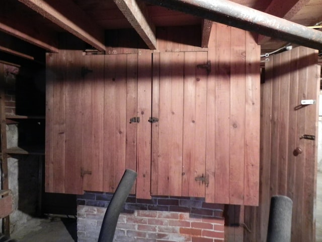 interior space with beam ceiling and wooden walls