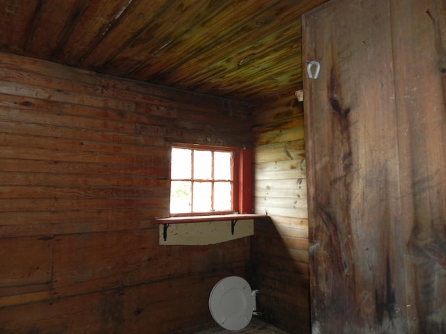 interior space with wooden walls, toilet, and wood ceiling