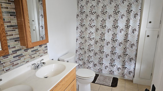 bathroom featuring tile patterned flooring, vanity, toilet, and backsplash