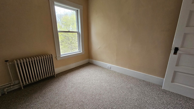 empty room with carpet and radiator heating unit