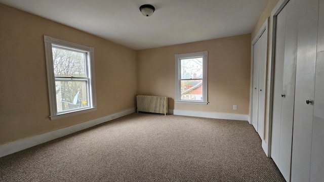 unfurnished bedroom featuring carpet flooring and radiator