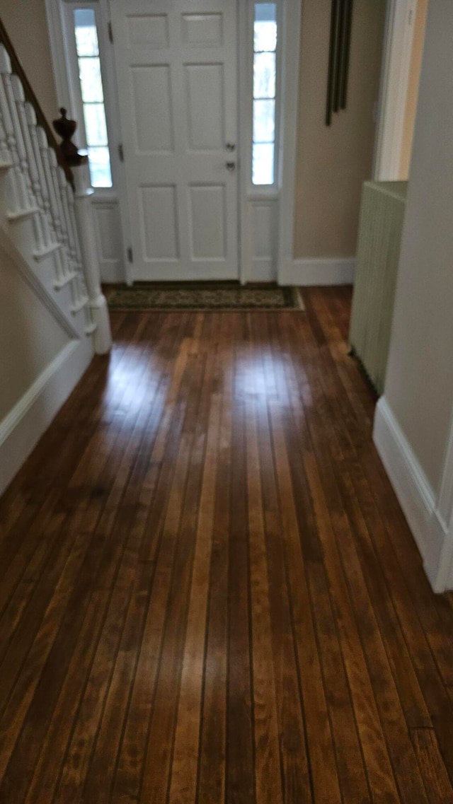 foyer entrance with dark wood-type flooring and radiator