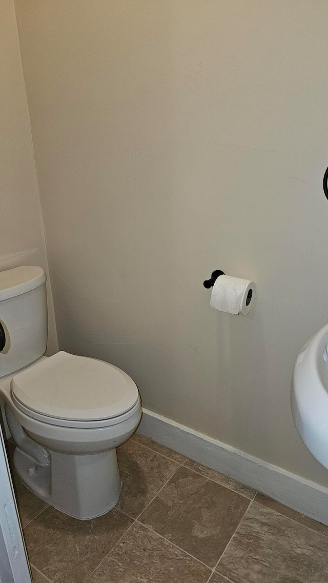 bathroom with toilet and tile patterned floors