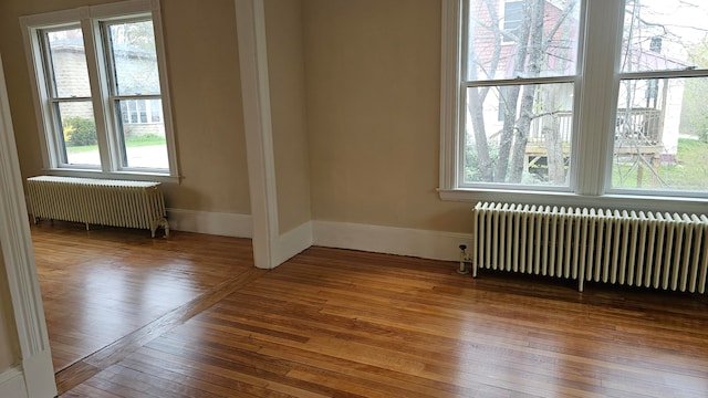 unfurnished room with a wealth of natural light and radiator heating unit