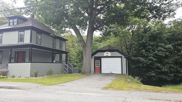 view of home's exterior with a garage, a porch, and an outbuilding