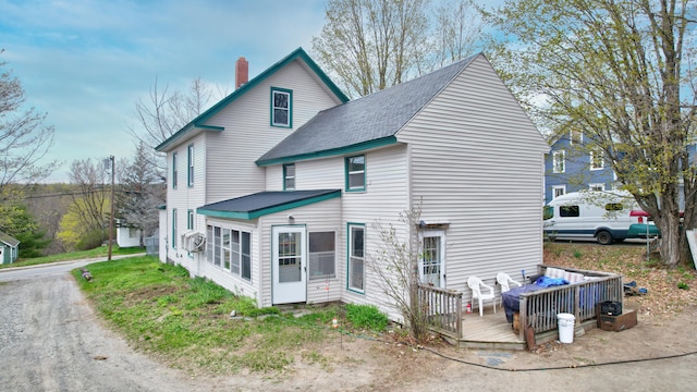 rear view of house featuring a wooden deck