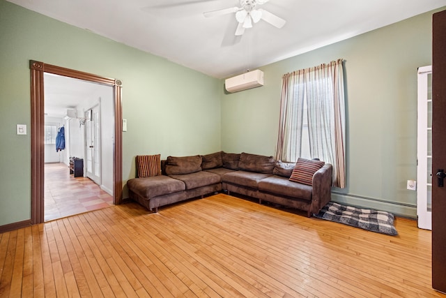 tiled living room with a baseboard heating unit, ceiling fan, and an AC wall unit