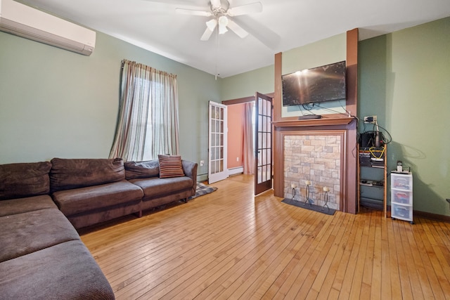 living room featuring a wealth of natural light, ceiling fan, an AC wall unit, and light wood-type flooring