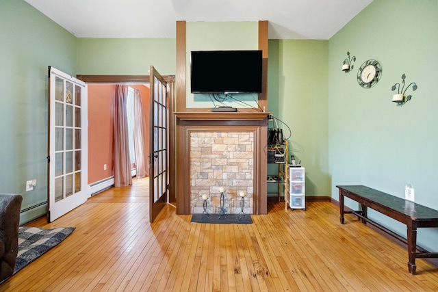 living room featuring hardwood / wood-style flooring, a baseboard radiator, and french doors