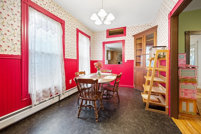 dining space featuring a notable chandelier, wood-type flooring, and a baseboard heating unit